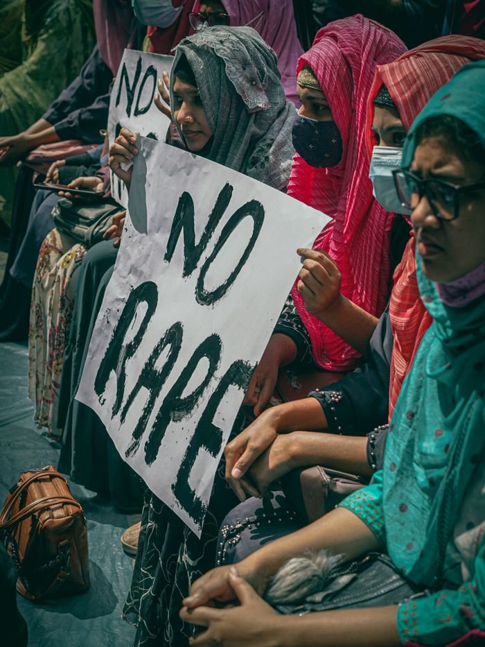 our-story Group of women holding signs protesting against rape, highlighting social issues and activism.