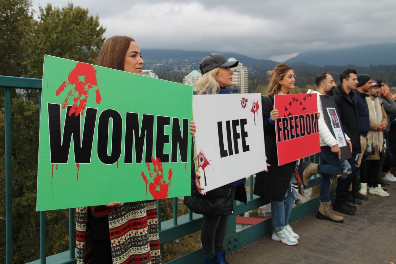 about-us A group of women hold signs for female empowerment and freedom during a protest in Vancouver.