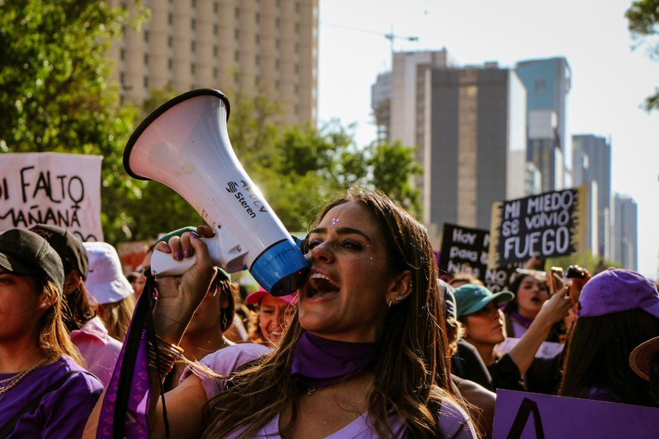 Crafting Captivating Headlines: Your awesome post title goes here Diverse crowd at a women's empowerment protest, raising voices and holding signs.